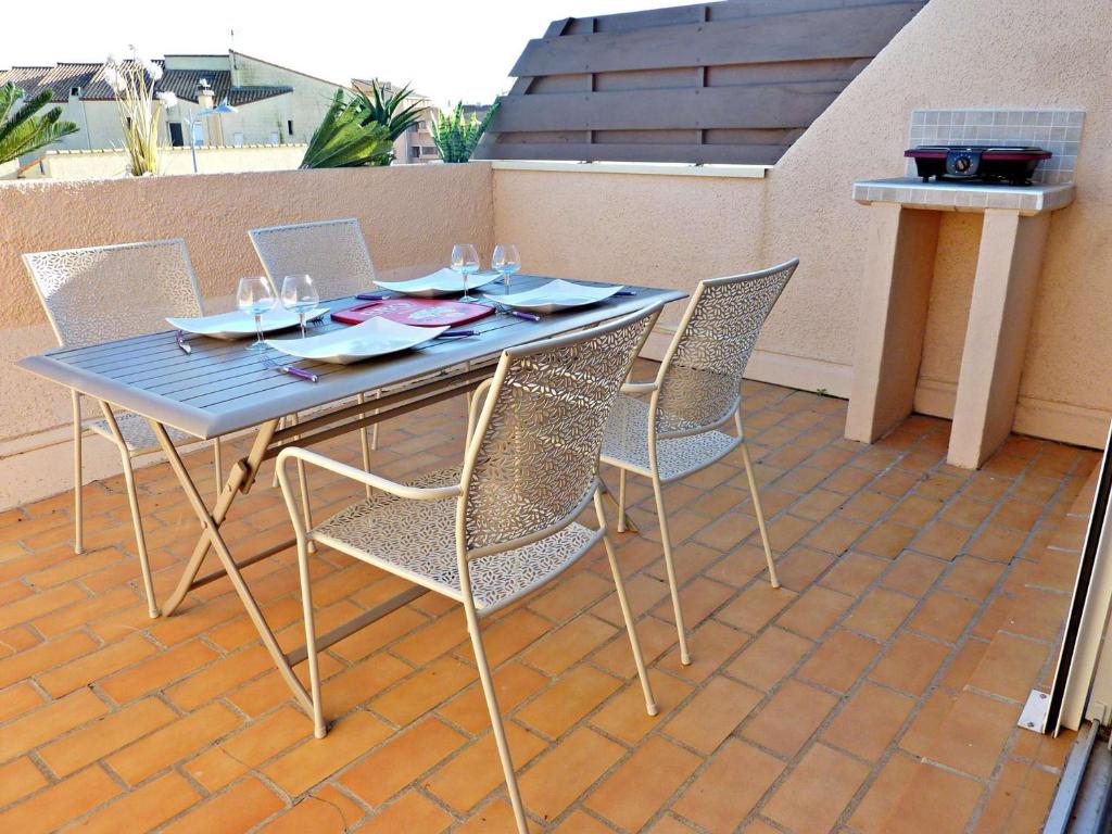 einen blauen Tisch und Stühle auf einer Terrasse in der Unterkunft Appartement Marseillan-Plage, 2 pièces, 4 personnes - FR-1-387-162 in Marseillan