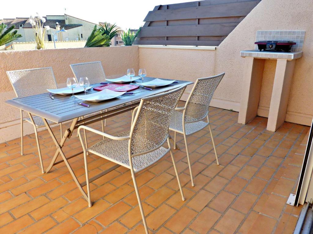une table et des chaises bleues sur une terrasse dans l'établissement Duplex rénové avec clim, terrasse et parking à Marseillan - FR-1-387-162, à Marseillan