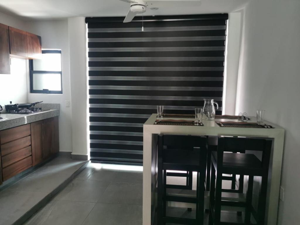 a kitchen with a large window with a black curtain at dept Miraflores in Zihuatanejo