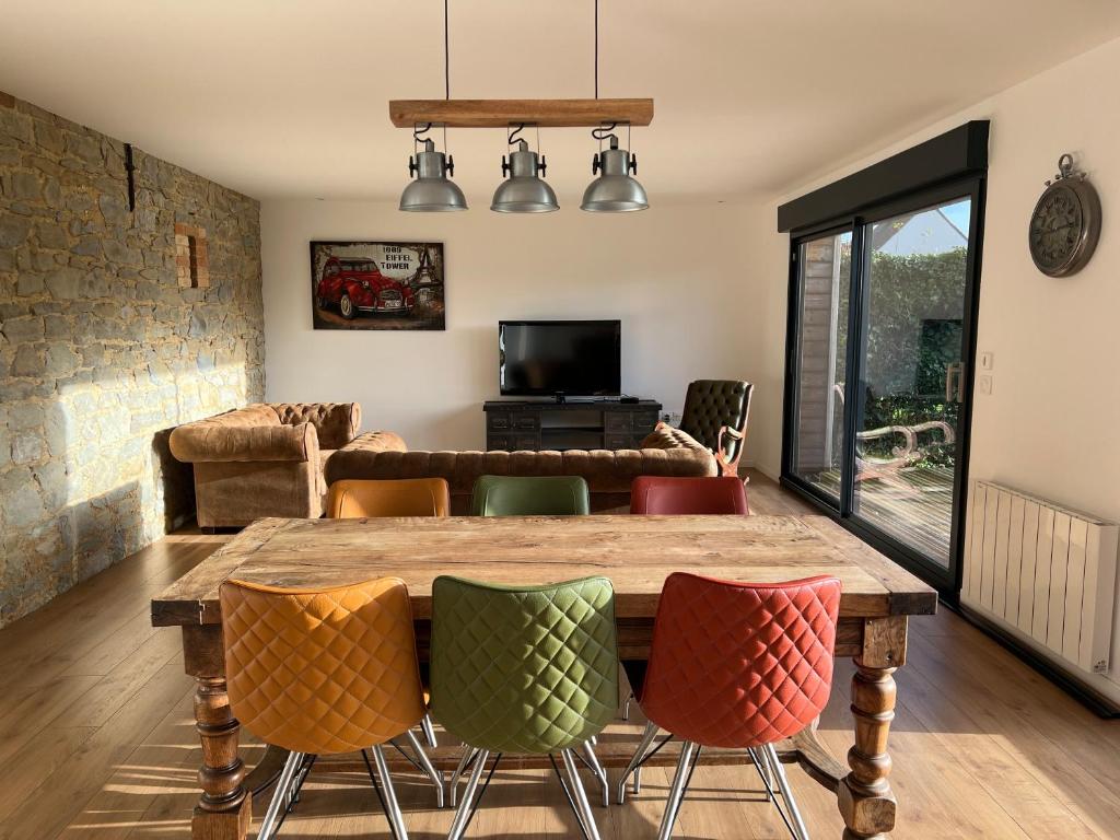un salon avec une table et des chaises en bois dans l'établissement Songes en Côte d Opale, à Conteville-lès-Boulogne