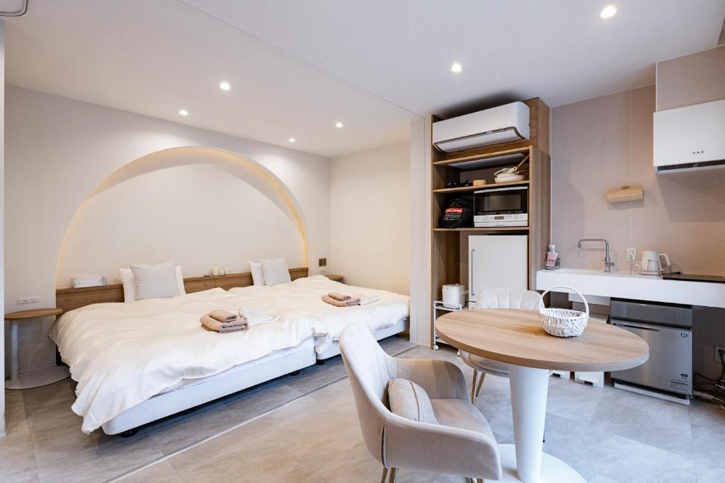 1 dormitorio con cama, mesa y cocina en R;MOGAMI - Vacation STAY 25480v 