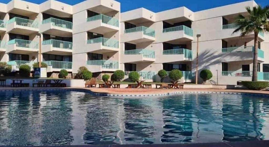 un hôtel avec une piscine en face d'un bâtiment dans l'établissement Estudio Frente Al Mar Posada, à San Carlos