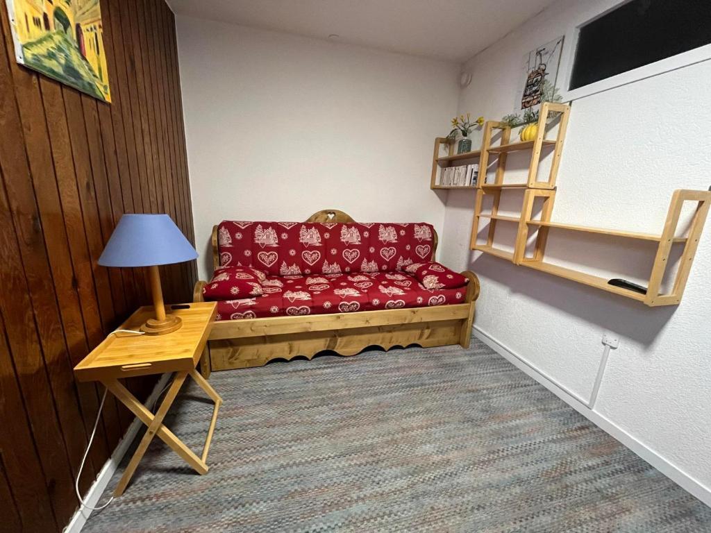 uma sala de estar com um sofá vermelho e uma mesa em Studio Avoriaz, 1 pièce, 2 personnes - FR-1-633-16 em Avoriaz