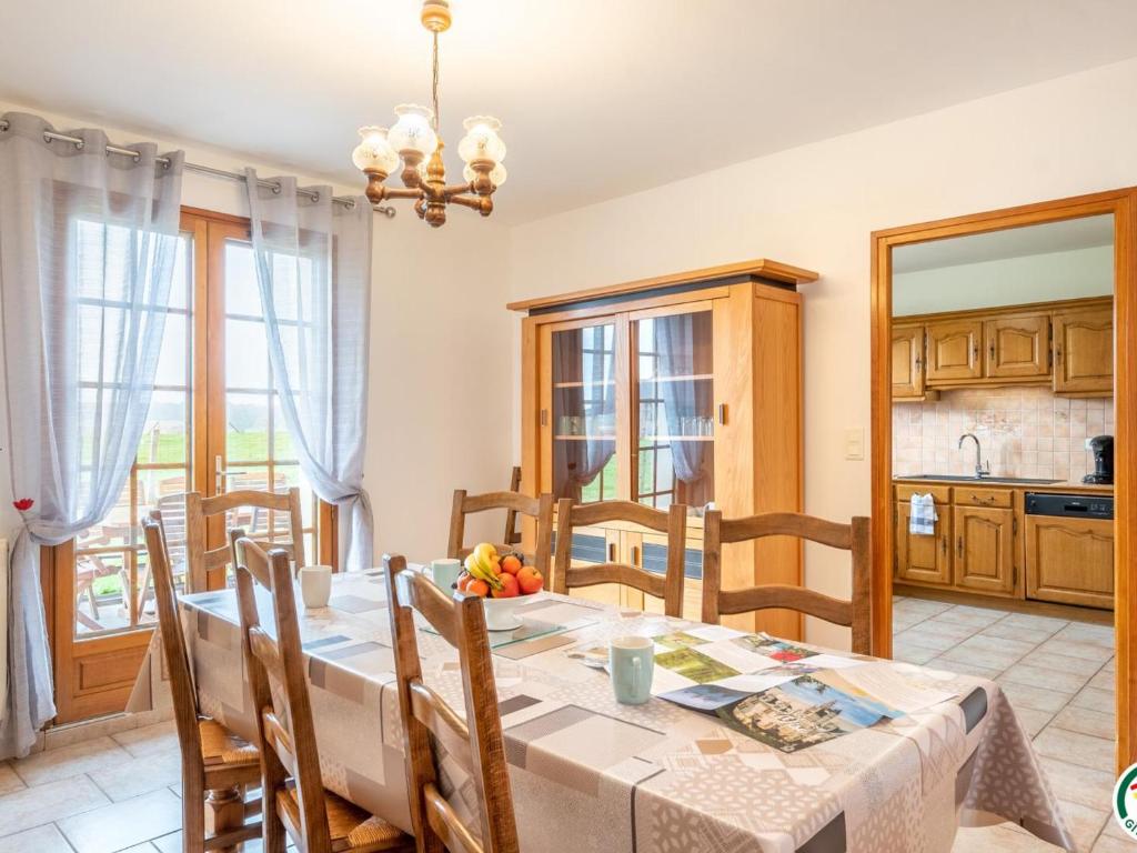 eine Küche und ein Esszimmer mit einem Tisch und Stühlen in der Unterkunft Gîte Ernemont-Boutavent, 5 pièces, 7 personnes - FR-1-526-28 