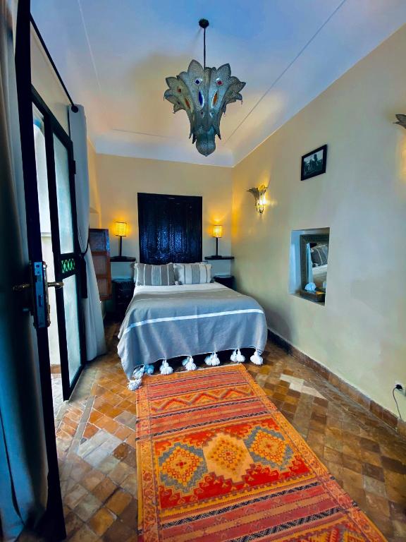 a bedroom with a bed with a rug in it at Riad El Youssoufi in Marrakesh