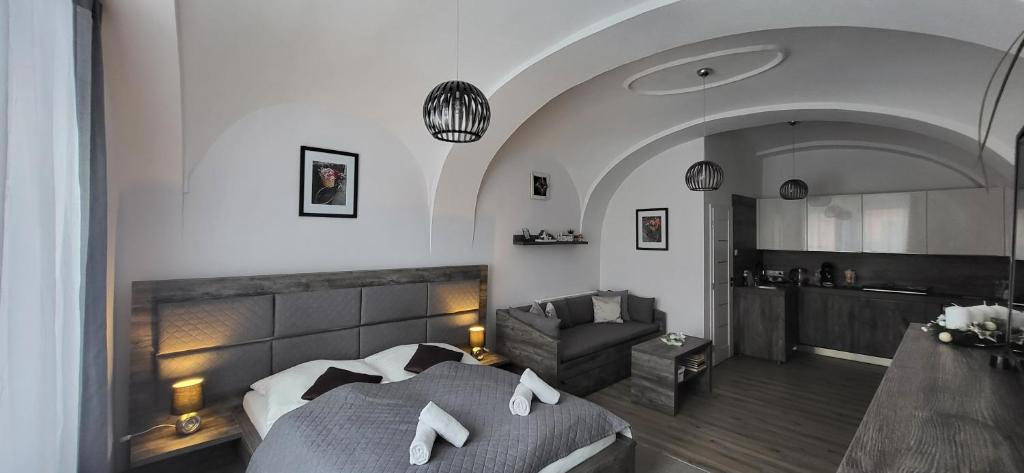 um quarto de hotel com uma cama e um sofá em Studio apartmán Kežmarok em Kežmarok