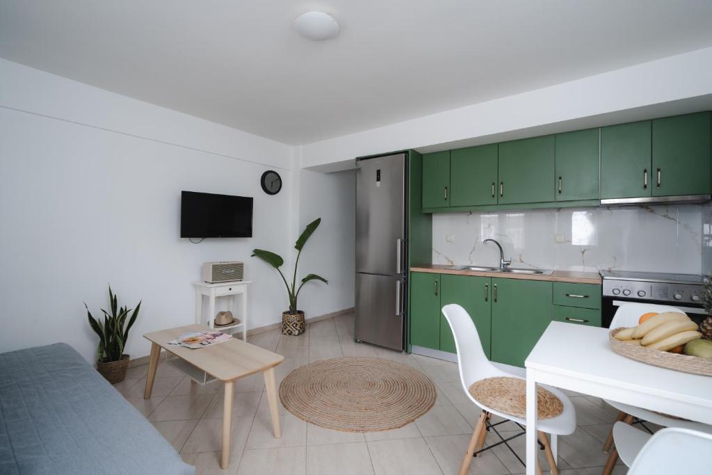 a kitchen with green cabinets and a table with chairs at K-houses P in Lefkada Town