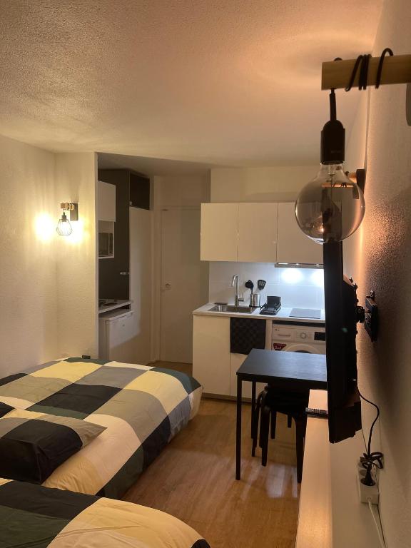 une chambre avec un lit et une table et une cuisine dans l'établissement T2D Apartment - Suite UR proche Disneyland Paris, à Bussy-Saint-Georges