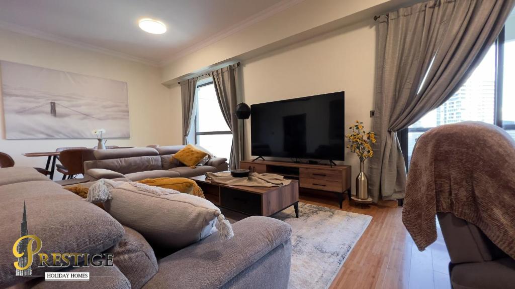 ein Wohnzimmer mit Sofas und einem Flachbild-TV in der Unterkunft Prestige in Dubai