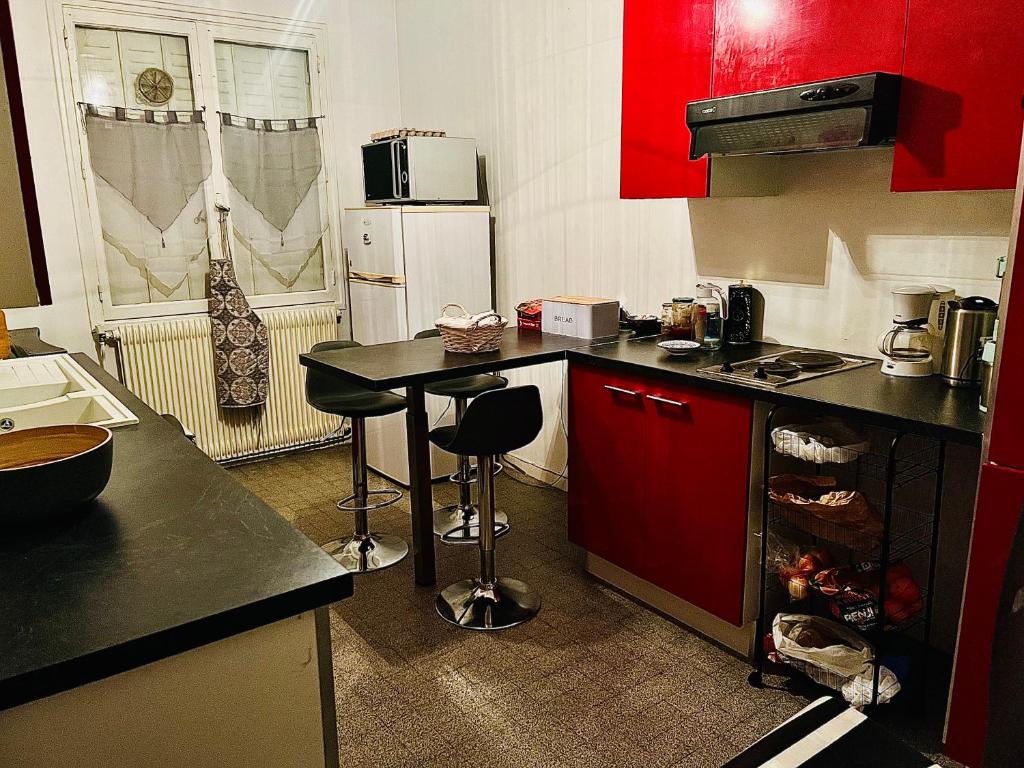 uma cozinha com armários vermelhos e uma mesa com bancos em Saxe Cosy Garibaldi em Lyon