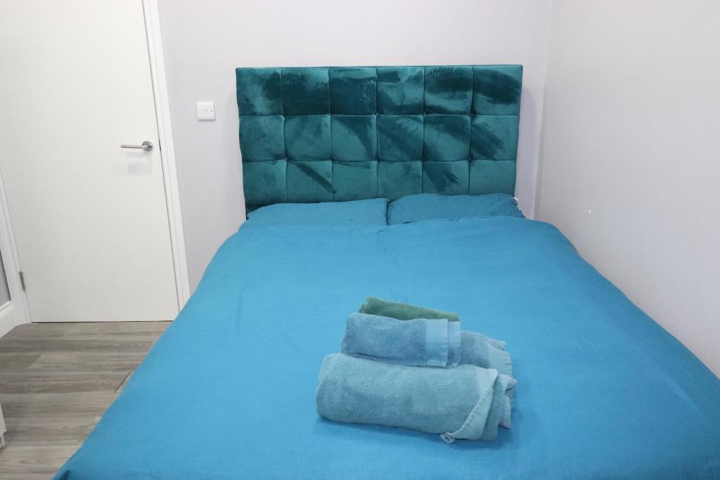 a blue bed with two pillows on top of it at Ground Floor 1 Bed Flat Dartford- 1 - Fully Equipped - Fibre Wifi - AIRPORT PICK-DROP AVAILABLE in Dartford