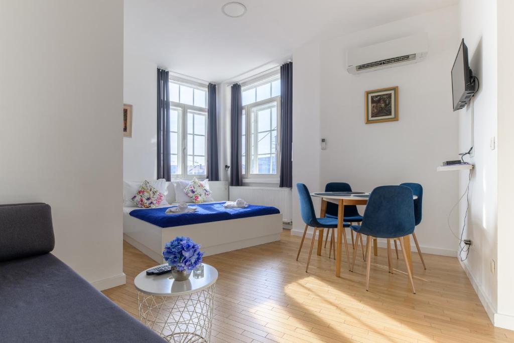 Niva Rooms & Studio Apartment في زغرب: غرفة معيشة مع أريكة وطاولة