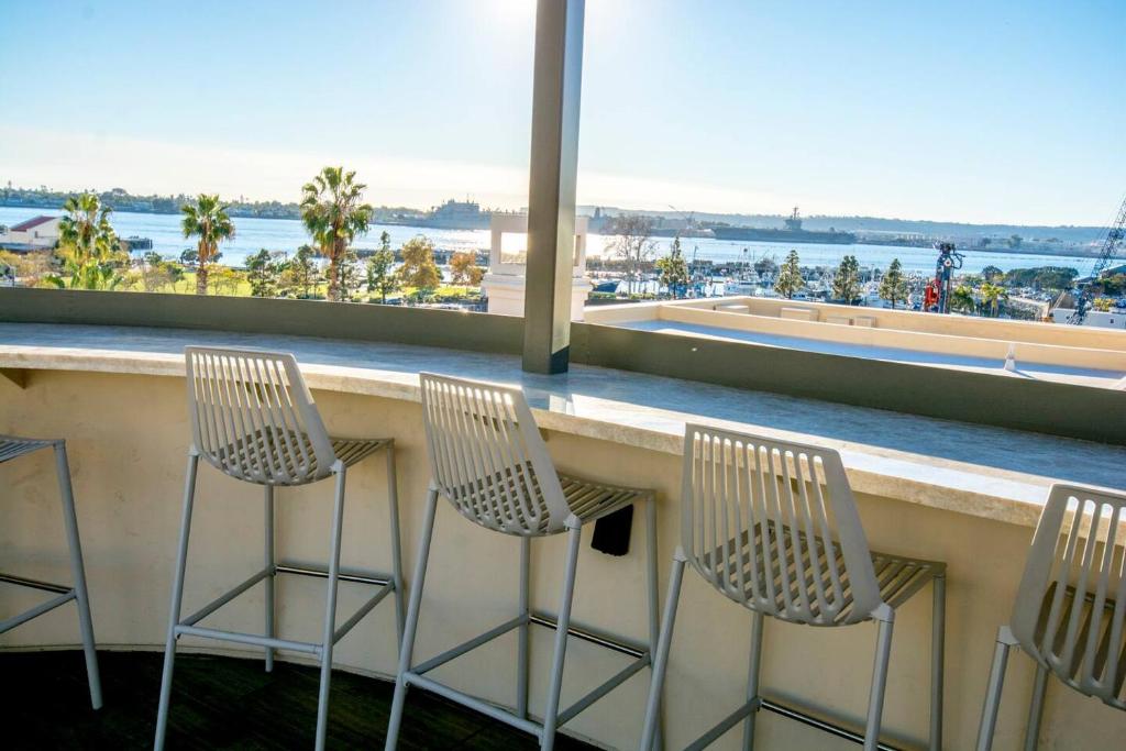 two chairs sitting at a bar with a view of the ocean at Bay Views & Gaslamp/Little Italy/Convention 1BD in San Diego