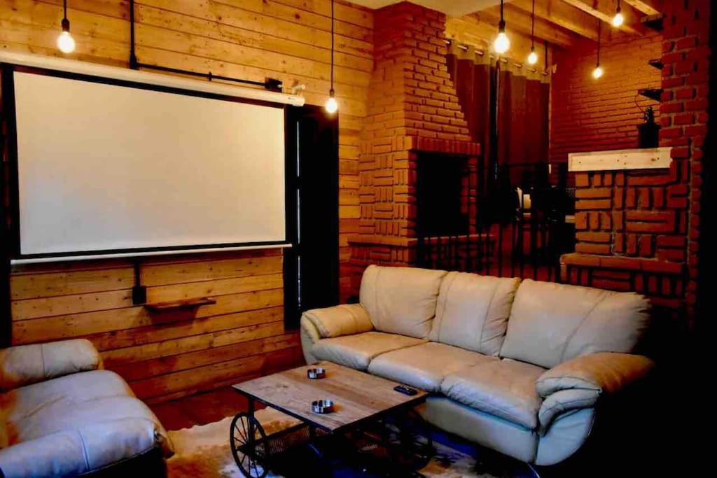ein Wohnzimmer mit einem Sofa und einem großen Bildschirm in der Unterkunft Sin lugar 