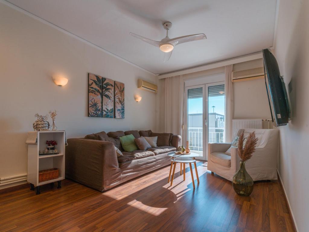 ein Wohnzimmer mit einem Sofa und einem Tisch in der Unterkunft Marousi Cozy Apartment in Athen