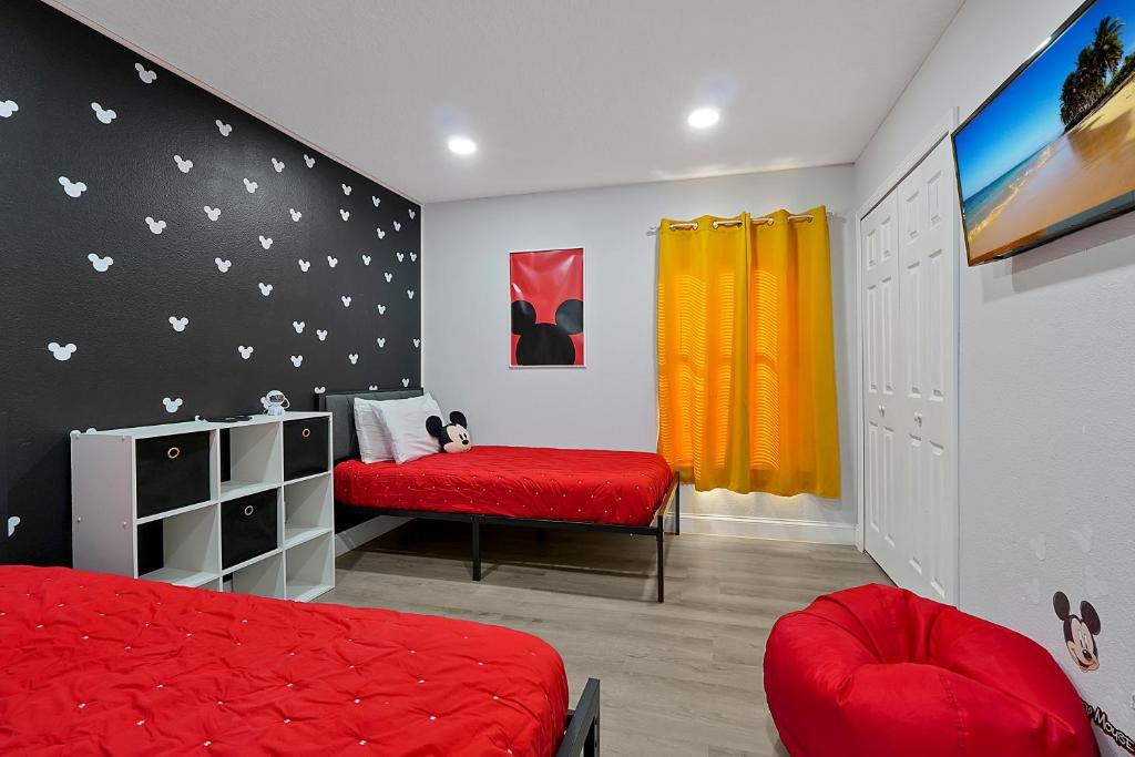 1 dormitorio con cama roja y banco rojo en Your Family Fun Villa w Pool, Game room, all you need, close to Disney & more, en Davenport