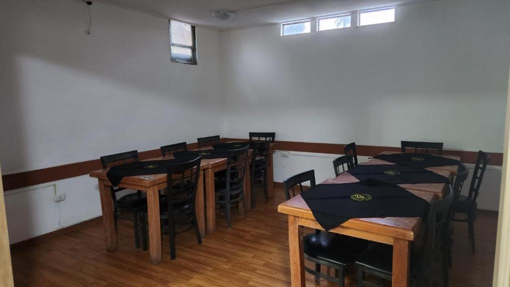 een eetkamer met houten tafels en stoelen. bij Residencial F y V Spa in Rancagua