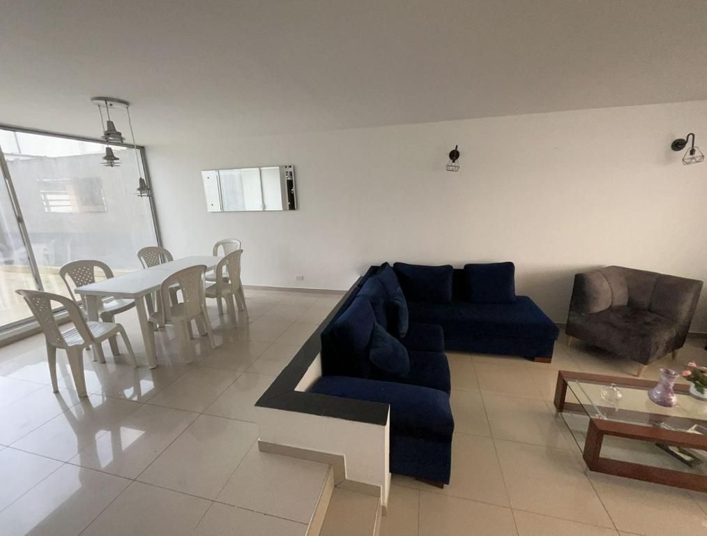 sala de estar con sofá azul y mesa en Casa Chimenea a 5 minutos del Aeropuerto en Bogotá