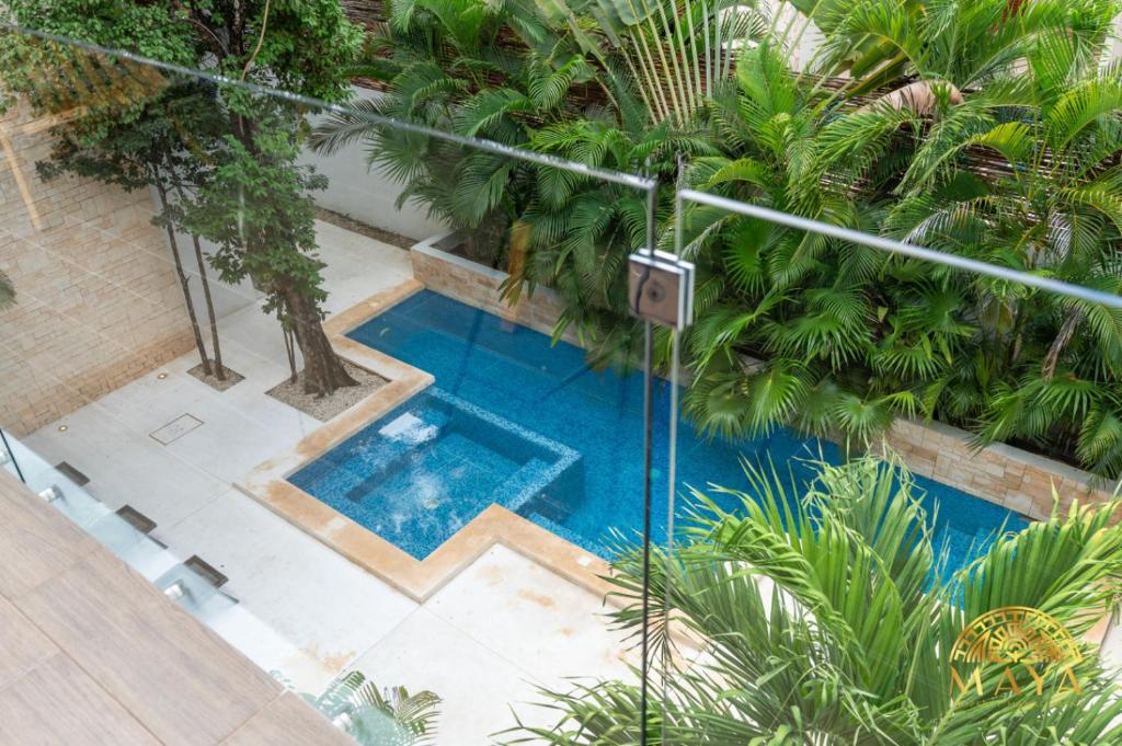 トゥルムにあるSelvaterra 102 Lux 2BR Large Condo in Aldea Zamaのヤシの木のあるプールの上空からの眺め