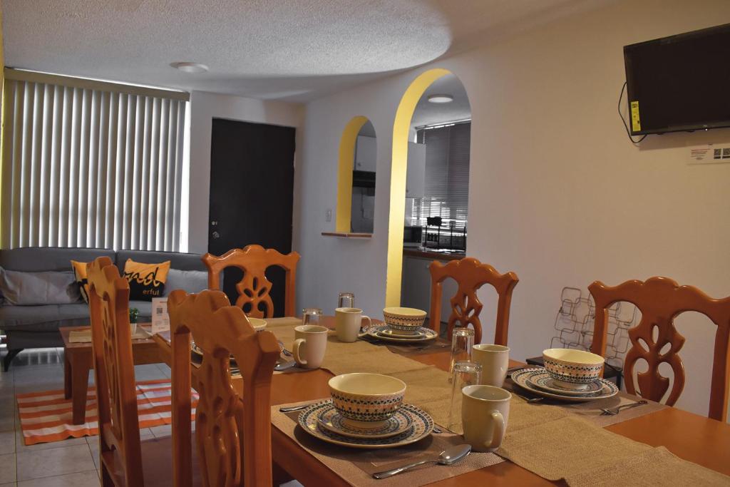 un comedor con mesa, sillas, mesa y sillón en Alojamiento cómodo: Casa ideal en Morelia