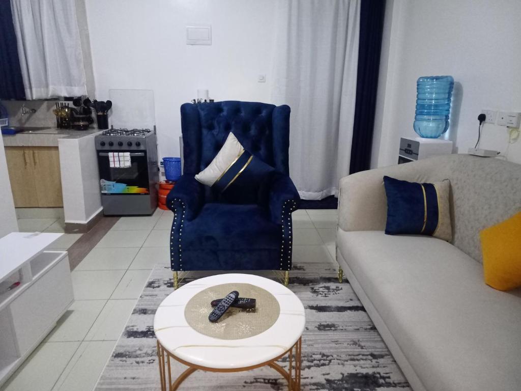 Blissful Lynn's Staycation في نيروبي: غرفة معيشة مع أريكة وطاولة