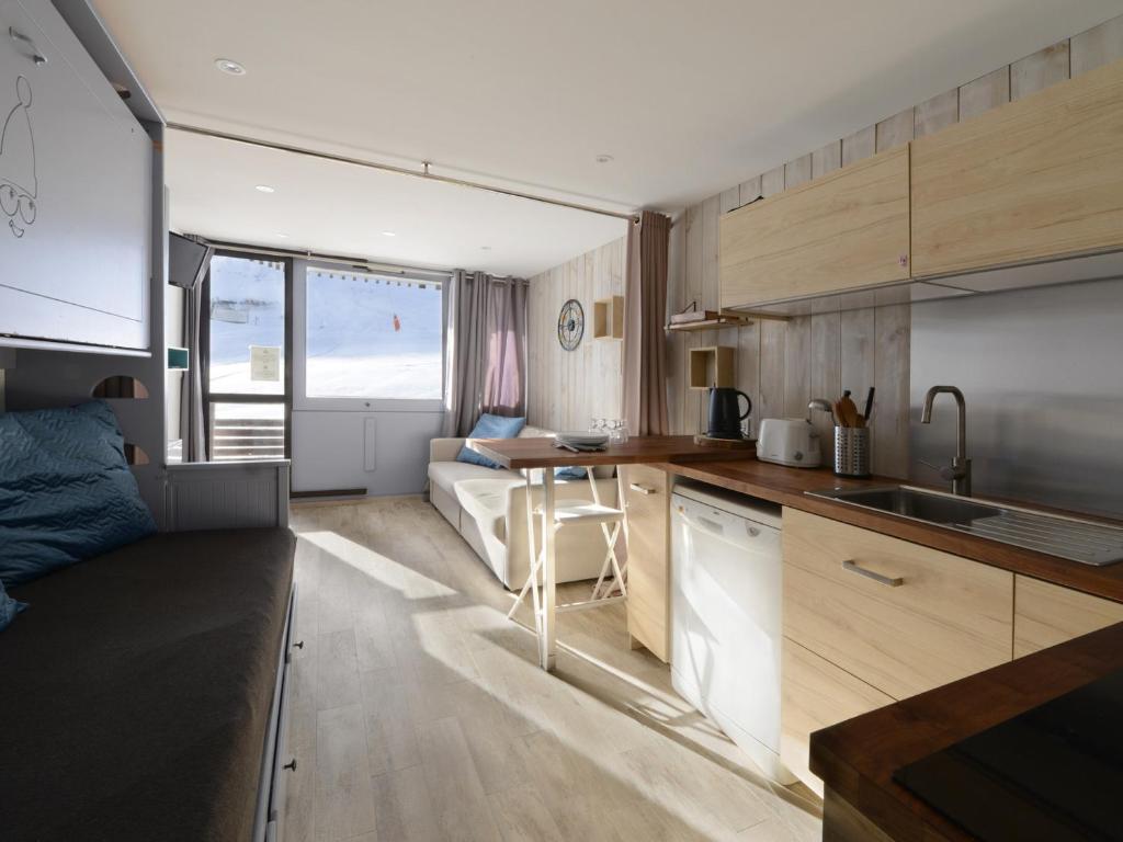 une cuisine et un salon avec un canapé dans une pièce dans l'établissement Studio confort rénové, balcon sud, skis aux pieds - FR-1-181-2556, à Aime La Plagne