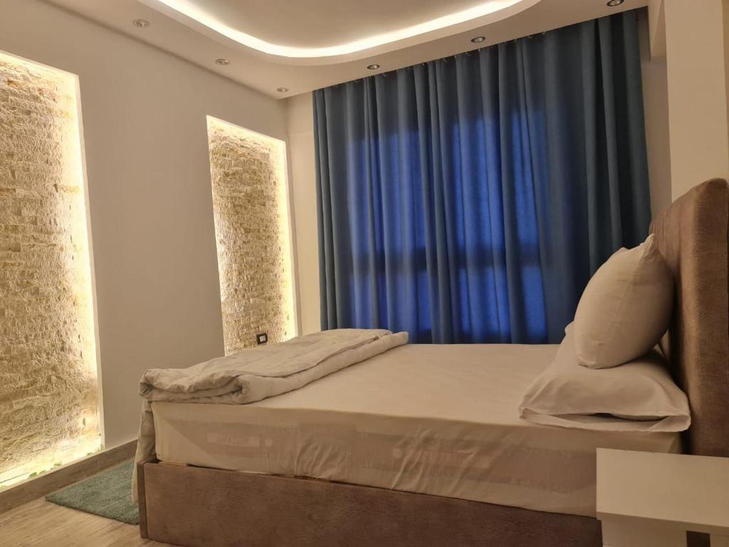 a bedroom with a bed with a blue window at شقة فاخرة مكيفة تري البحر مباشرة in Alexandria