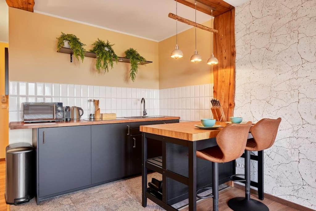 a kitchen with a wooden table and a counter at *Neues Loft*- nahe Frankfurter Flughafen + Bahnhof in Neulsenburg