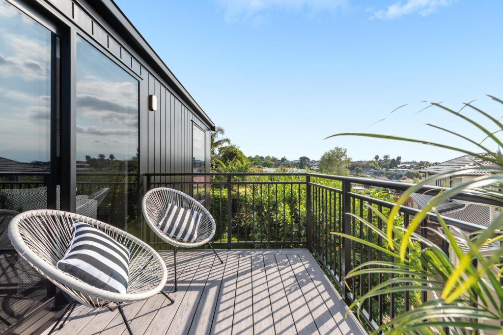 a balcony with two chairs and a table at Luxury Apartment retreat in Tauranga