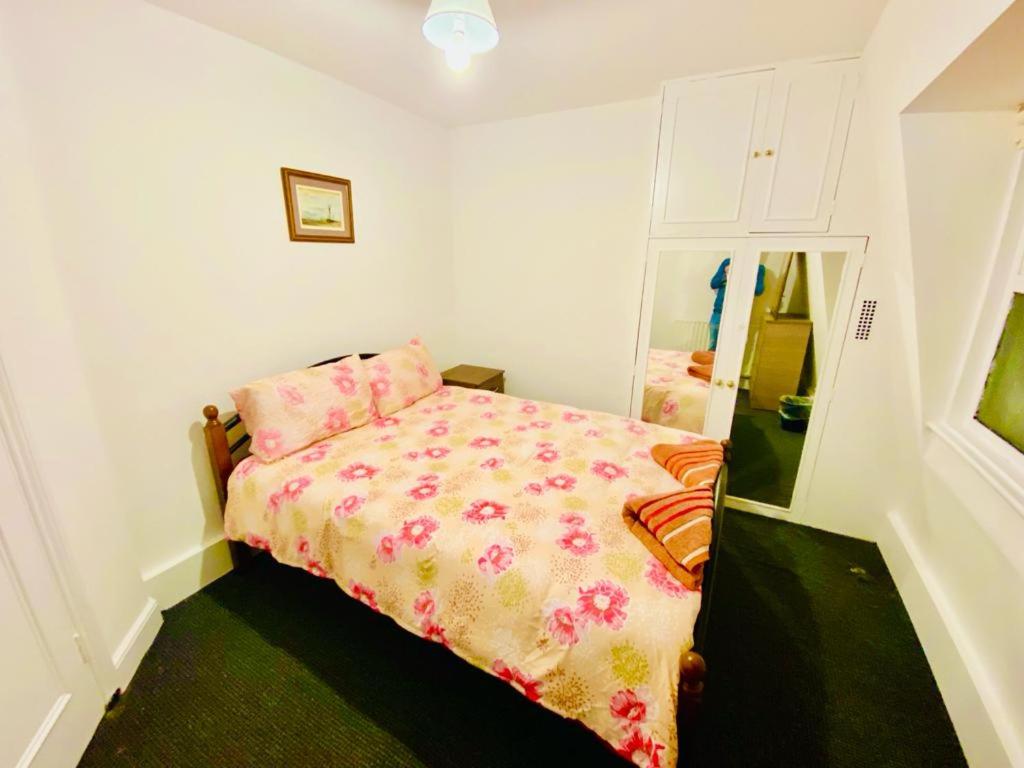 - une petite chambre avec un lit et un miroir dans l'établissement Two Bedroom Property in Central London, à Londres
