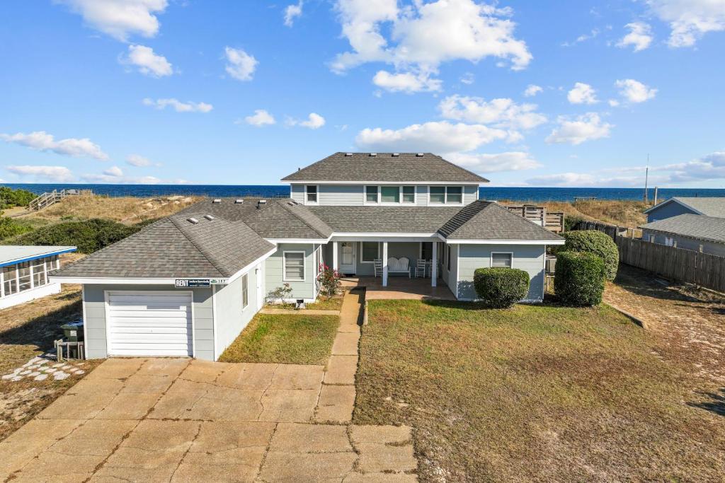 a house on the beach with the ocean in the background at Bel Isle in Southern Shores