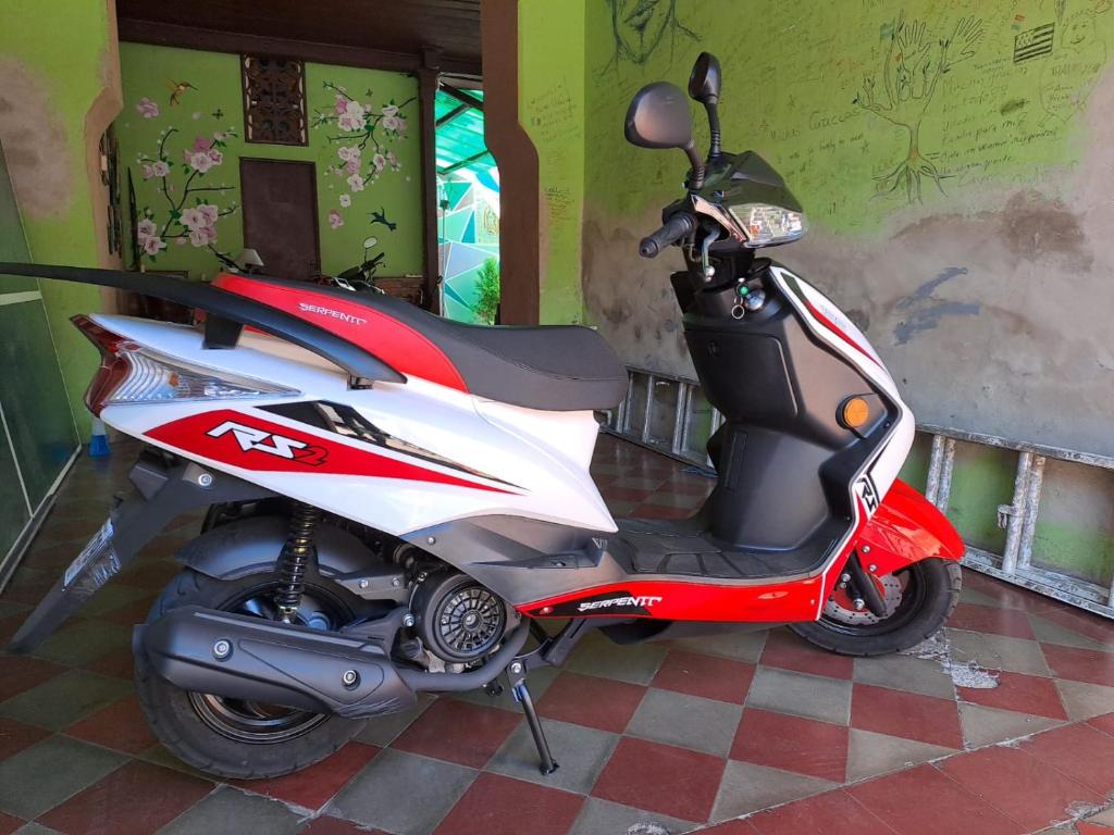 a red and white scooter parked in a room at Casa Vieja Guest House in Santa Ana