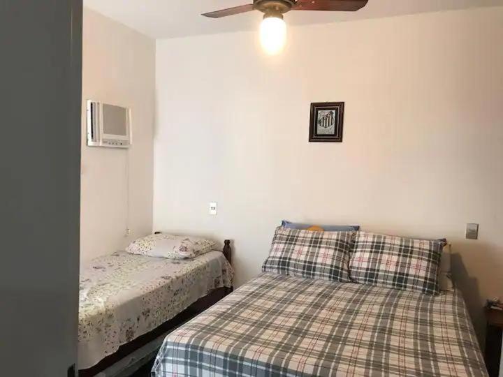 1 Schlafzimmer mit 2 Betten und einem Deckenventilator in der Unterkunft Apartamento no guaruja- praia enseada in Guarujá