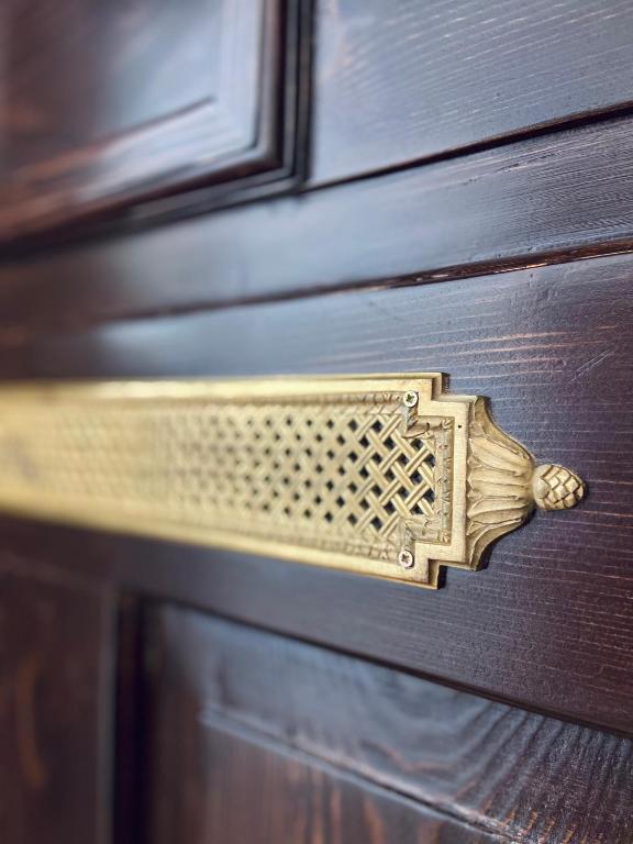 a gold door handle on a wooden door at Zentrum Vintage Appartments in Braşov