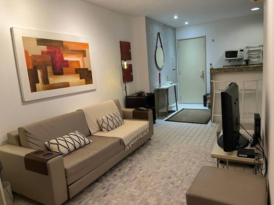 sala de estar con sofá y TV en Apartamento Flat Lagoa en Río de Janeiro