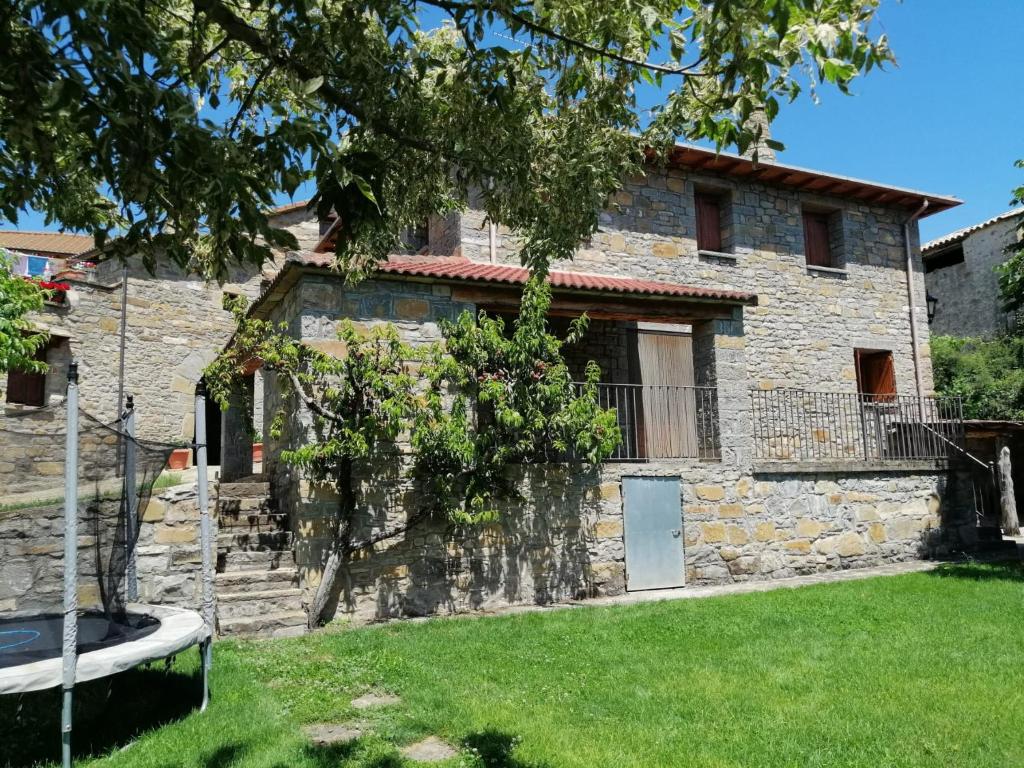 una vieja casa de piedra con un patio delante en Casa la Nau, en Huesca