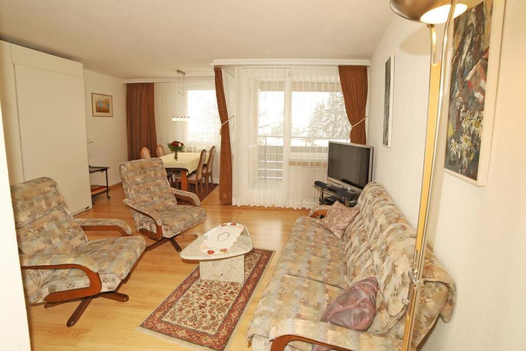 un salon avec un canapé, des fauteuils et une télévision dans l'établissement Ferienwohnung in Davos platz WEF 2024, à Bolgen