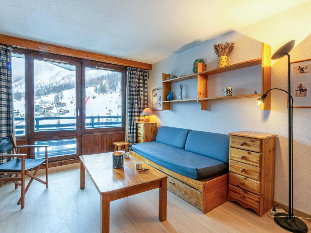 un salon avec un canapé bleu et une table dans l'établissement Appartement cosy à La Daille, skis aux pieds, WiFi, animaux acceptés - FR-1-694-192, à Val dʼIsère