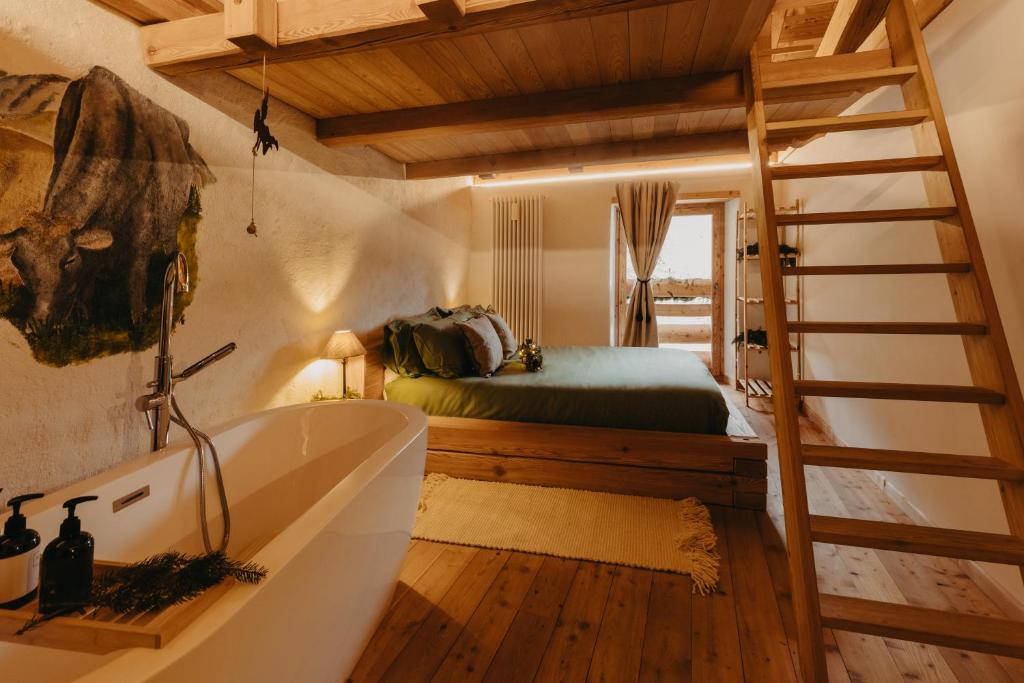 łazienka z wanną i łóżko w pokoju w obiekcie Odomi maso nel bosco - Eleganza e Relax nella Natura w mieście Sant'Orsola Terme