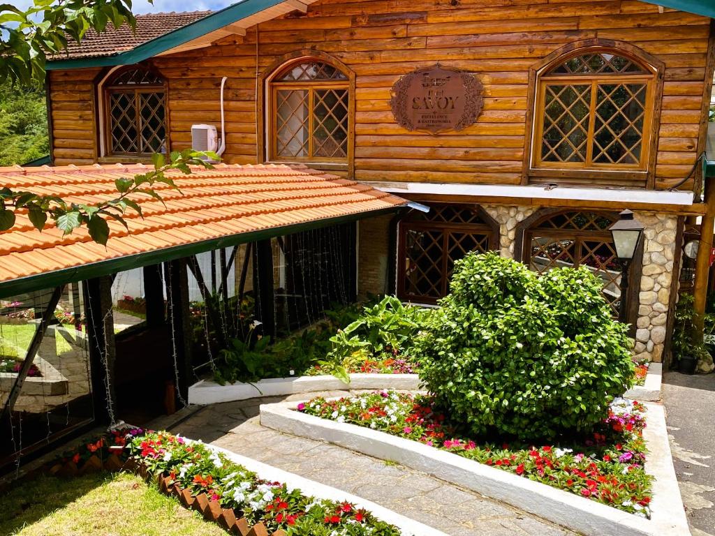 ein Holzgebäude mit Blumen davor in der Unterkunft Hotel Savoy Excellence in Campos do Jordão