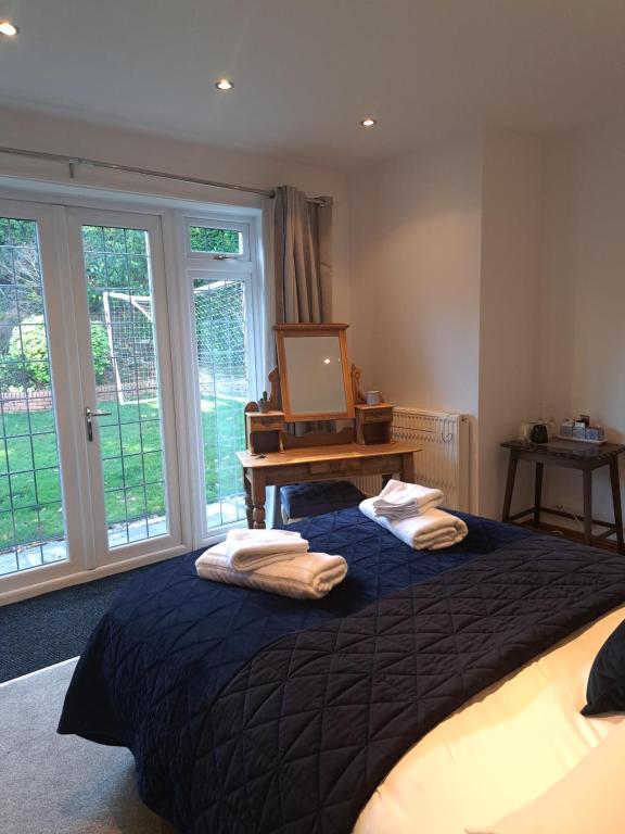 a bedroom with a large bed with towels on it at Garden Room in Bromsgrove
