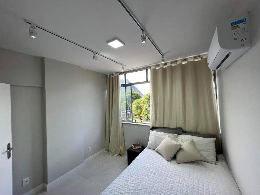 a bedroom with a white bed with a window at Melhor Localização! Botafogo-URCA in Rio de Janeiro