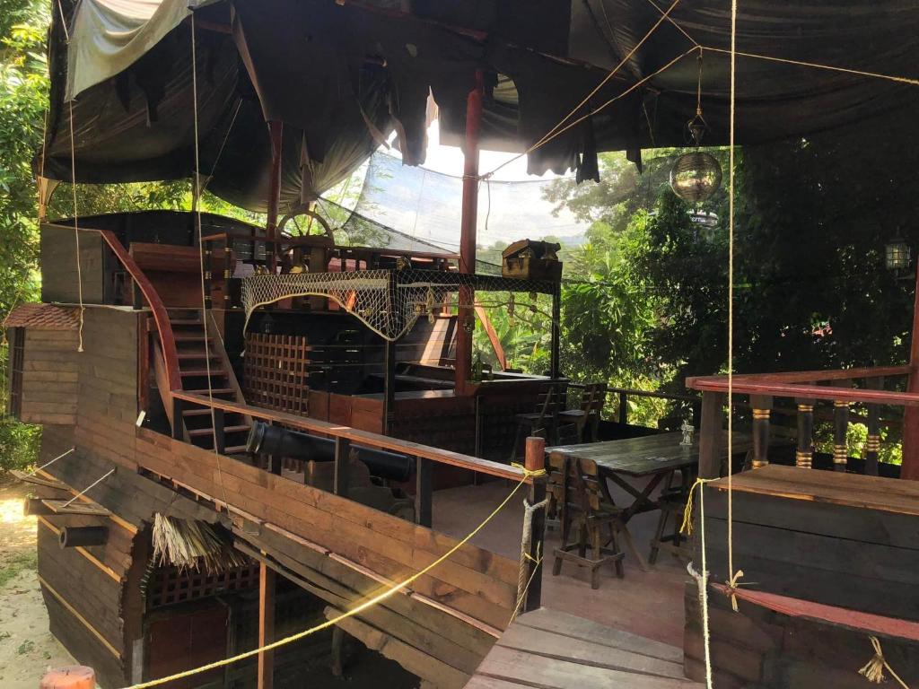 une terrasse en bois avec une table et un parasol dans l'établissement La Playita, à Guachaca