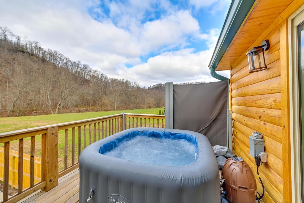 a hot tub on the deck of a cabin at Riverside Beattyville Cabin with Kayaks and Fire Pit! in Beattyville