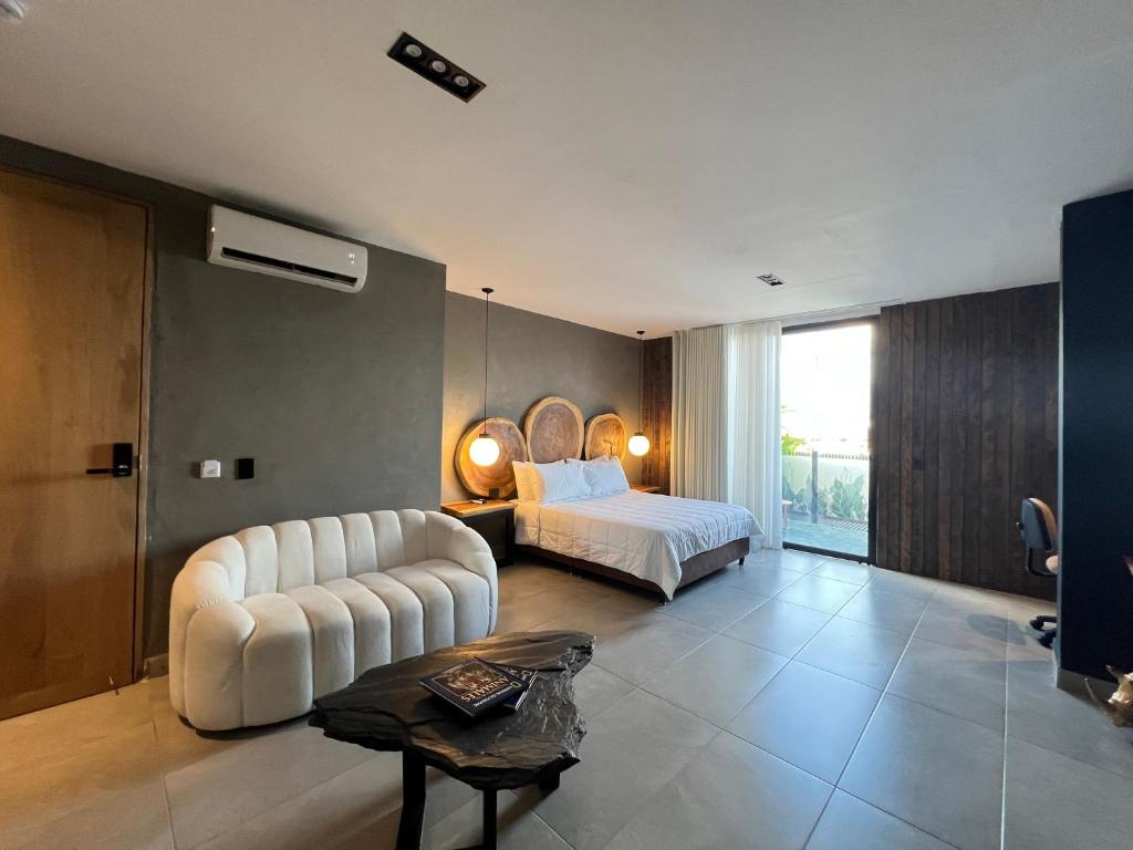 - une chambre avec un lit, un canapé et une table dans l'établissement Hotel Zelva Negra, à Medellín