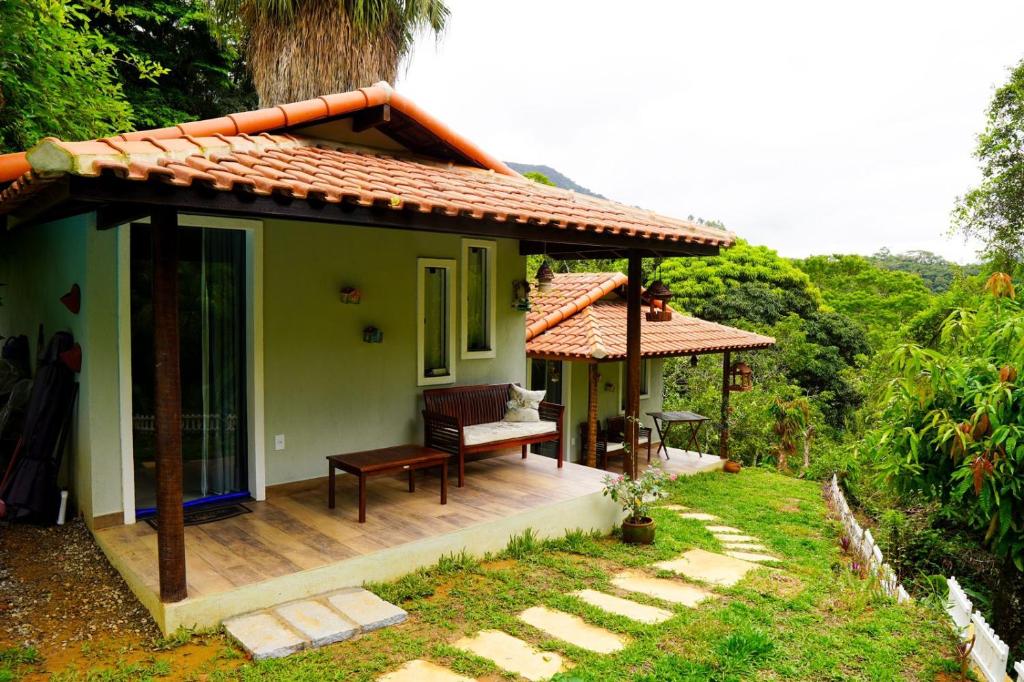 a house with a porch with a bench on a deck at Refúgio da Montanha - Cascata - Lumiar in Lumiar