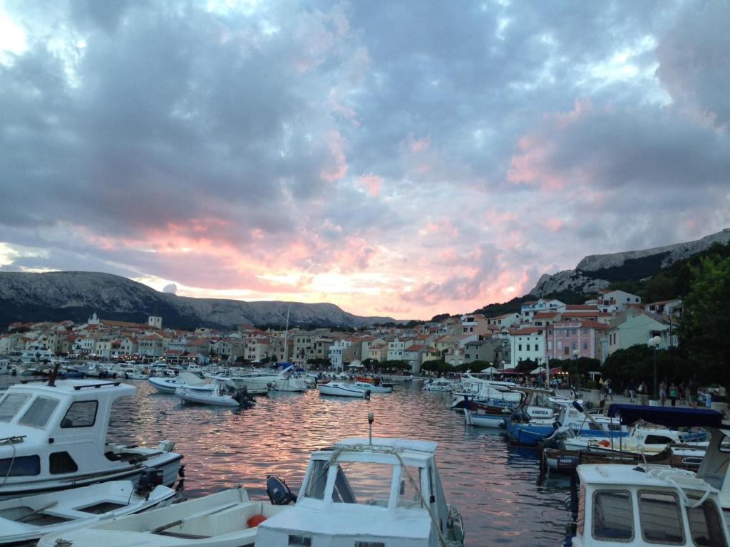a group of boats docked in a marina at sunset at Apartment Sersic in Baška