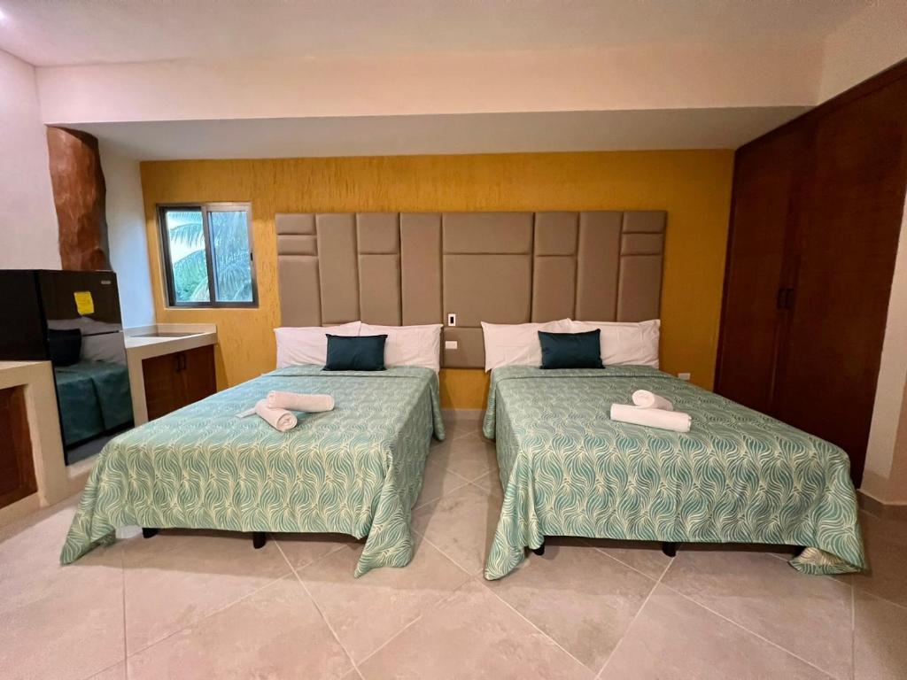 a bedroom with two beds with towels on them at Suites Valentina in Puerto Morelos
