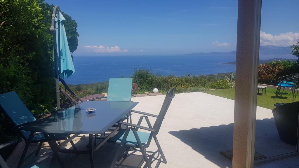 une table et des chaises avec vue sur l'océan dans l'établissement Villa Acqua Doria, à Coti-Chiavari
