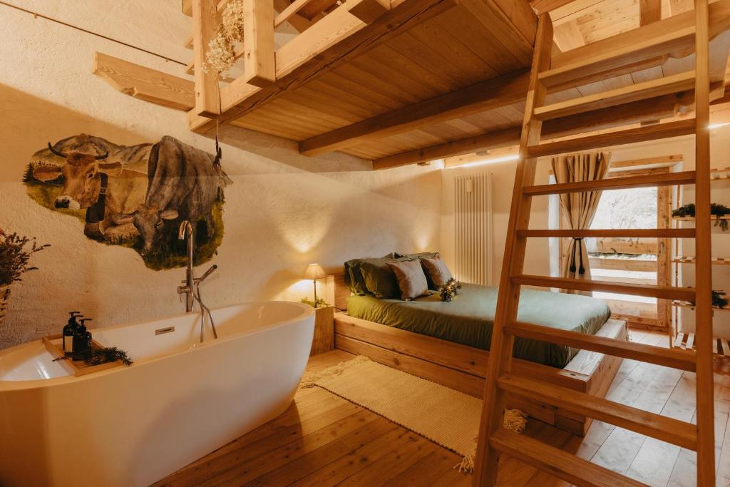 łazienka z wanną, łóżkiem i drabiną w obiekcie Odomi maso nel bosco - Eleganza e Relax nella Natura w mieście Sant'Orsola Terme